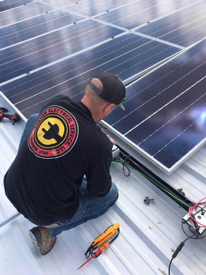 A Custom Electrical commercial electrical contractor installing a major solar power panel for electrial needs.
